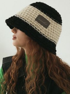 a woman with long hair wearing a black and white crochet beanie hat