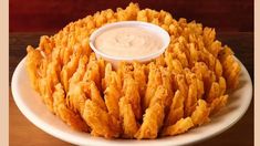 a white plate topped with fried food and dipping sauce