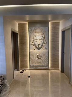 a large buddha statue sitting in the middle of a room with white walls and marble flooring