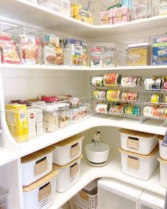 an organized pantry with lots of food in containers and bins on the bottom shelf