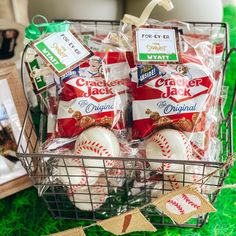 a basket filled with baseballs and snacks on top of a green grass covered field