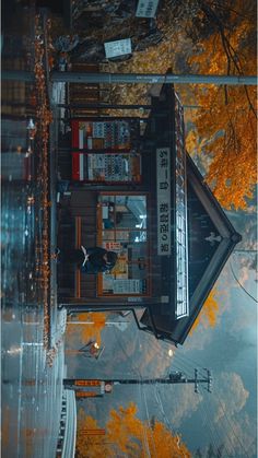 an aerial view of a building with autumn leaves on the ground and trees in the background