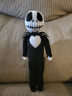 a knitted jack skellingy doll sitting on a couch