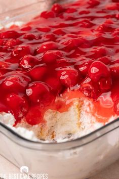 a close up of a cake in a pan with cherries on top and white frosting