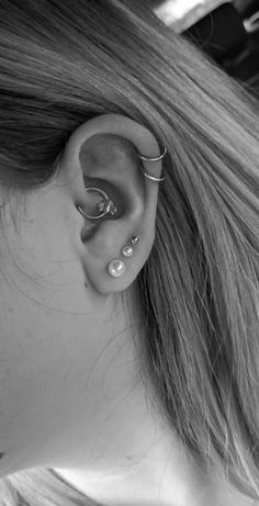 black and white photograph of a woman's ear with two piercings on it