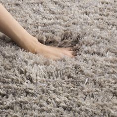 a person is laying on a shaggy rug with their foot in the middle of it