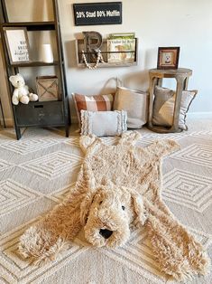 a teddy bear is laying on the floor next to some pillows and other decor items