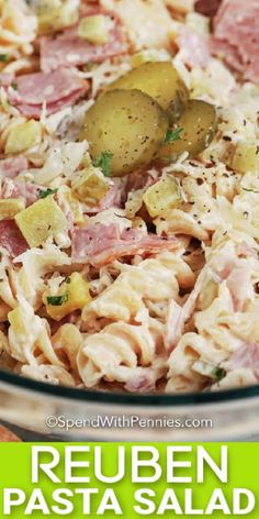 a bowl filled with pasta and vegetables on top of a wooden table