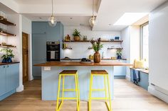 two yellow stools sit in front of a kitchen island