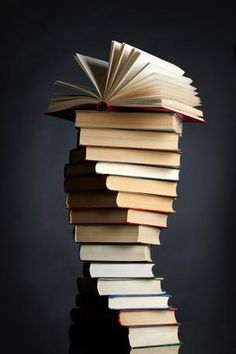 a stack of books sitting on top of each other in front of a black background