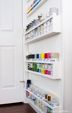 a white wall with shelves filled with paint and supplies