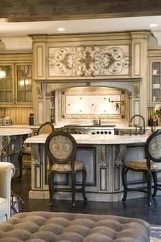 a kitchen with an island, stove and chairs in the middle of it's room