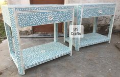 two blue and white side tables sitting next to each other