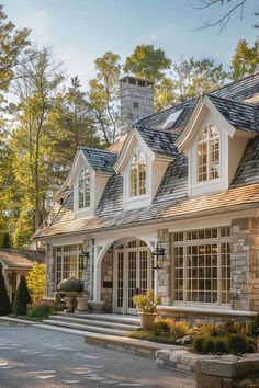 a large white house with lots of windows and stone steps leading to the front door