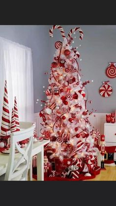 a red and white christmas tree decorated with candy canes, lollipops and candies