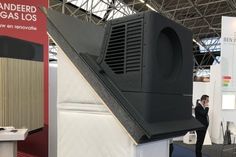 a man standing in front of an air conditioner on display at a trade show