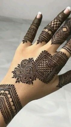 a woman's hand with henna tattoos on it