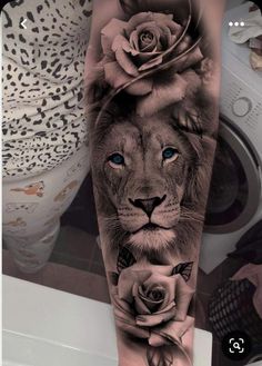 a lion with roses on his head and blue eyes is shown in this black and white tattoo