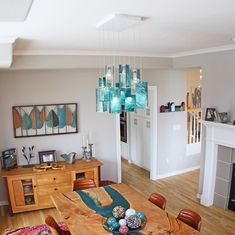 a dining room table with chairs and a chandelier hanging from the ceiling