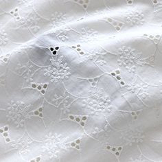 an embroidered white fabric with small flowers on it