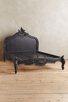 an antique black bed frame on the floor