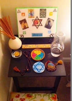 a small table with an assortment of items on it and a vase next to it