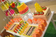 an assortment of desserts on display at a party or event, including pineapples, watermelon slices and strawberries