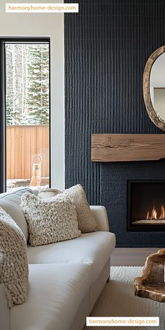 a living room with a white couch, fireplace and large mirror on the wall above it