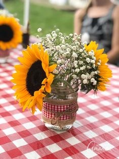 sunflowers and baby's breath in a mason jar on a picnic table