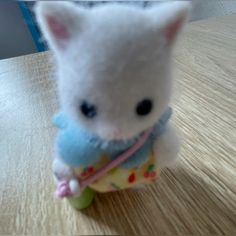 a small stuffed animal sitting on top of a wooden table