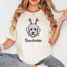 a woman wearing a t - shirt with a dog on it's chest and reindeer antlers on her head