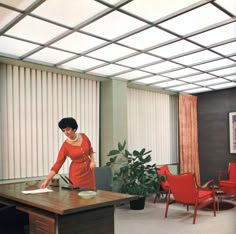 a woman standing at a desk in an office