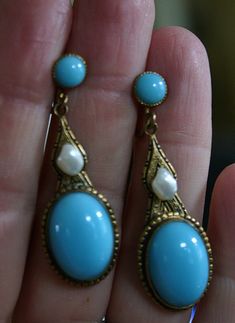 "Very fine pair of Czechoslovakian earrings from the Art Nouveau era, circa 1910. Beautifully shaped pendant earrings in gold tone appointed with French blue opaline type poured glass cabochons and glass button tops. The middle section accented with lovely natural baroque pearls. These pearls are often referred to as \"tooth\" pearls or Mississippi river pearls due to their unusual shape. The pearls are well matched and have beautiful lustrous nacre... amazing for  earrings over a hundred years Blue High Luster Earrings For Formal Occasions, Formal Blue High Luster Earrings, Blue Cabochon Earrings For Formal Occasions, Elegant Blue Cabochon Earrings, Victorian Turquoise Jewelry For Formal Occasions, Blue Elegant Earrings, Vintage Cabochon Dangle Earrings, Victorian Blue Earrings For Weddings, Blue Victorian Earrings For Wedding