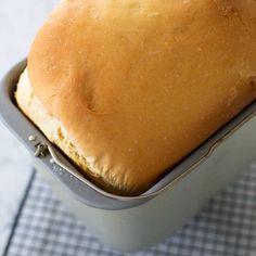 a loaf of bread sitting in a pan on top of a checkered table cloth