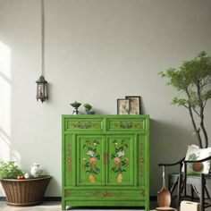 a green cabinet sitting in the middle of a room next to a potted plant