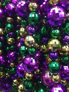 purple and green disco balls are stacked on top of each other in the same pattern