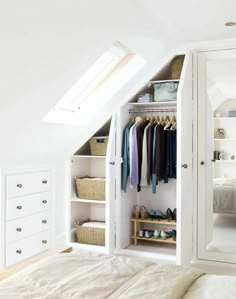 an attic bedroom with white walls and closets