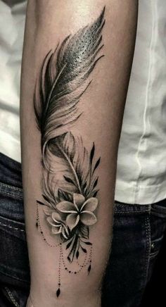 a black and white photo of a feather with flowers on it's side arm