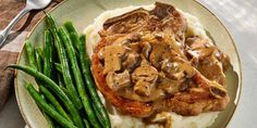 a plate with mashed potatoes, green beans and mushroom gravy