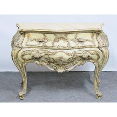 an antique chest with marble top and carved design on the front, sitting on a gray carpeted floor