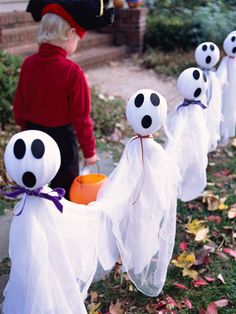 a little boy in red shirt and white ghost costumes