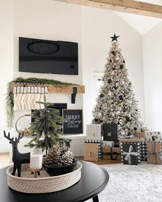 a living room with a christmas tree and presents on the table in front of it