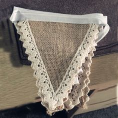 a piece of cloth hanging from the side of a book case with lace on it