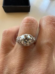 a close up of a person's hand with an engagement ring on their finger