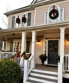 a house decorated for christmas with wreaths on the front porch and stairs leading up to it