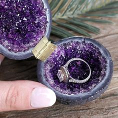 someone is holding their engagement ring in the middle of some kind of purple thing that looks like it's inside an egg