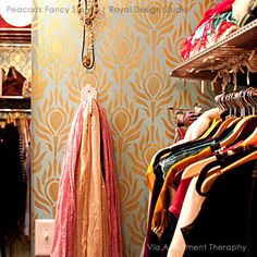 a closet filled with lots of clothes next to a wall mounted clock and light fixture