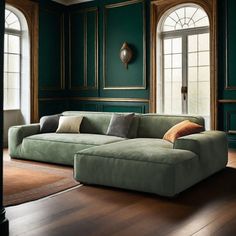 a living room with green walls and wood flooring is pictured in this image, there are two large windows on the far wall