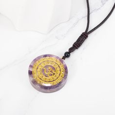 This Orgone Energy Om Amethyst Necklace Talisman is a powerful combination of Amethyst crystal and orgone energy. It's an orgone pendant and amethyst necklace in one stunning jewelry piece that will make you feel high spiritual vibrations. It is specially crafted with high-quality materials and has one of the most striking looks for an orgone amethyst stone pendant! Round Crystal Amulet Necklaces For Meditation, Amethyst Crystal Healing Necklace With Round Pendant, Purple Amulet Necklaces As Gifts, Amethyst Amulet Necklace For Meditation, Spiritual Amethyst Round Pendant Necklace, Spiritual Purple Round Pendant Necklace, Spiritual Amethyst Crystal Necklace, Spiritual Round Amethyst Crystal Necklace, Purple Crystal Healing Necklace