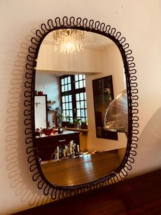 a mirror hanging on the wall above a wooden table